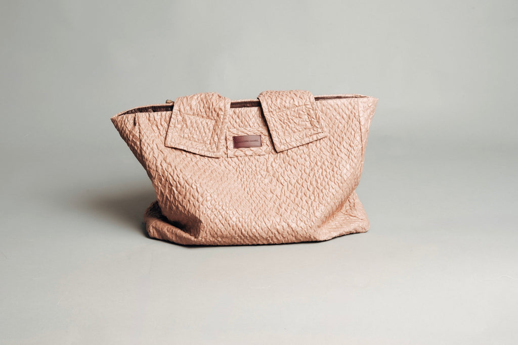 Pink textured handbag on a light gray background