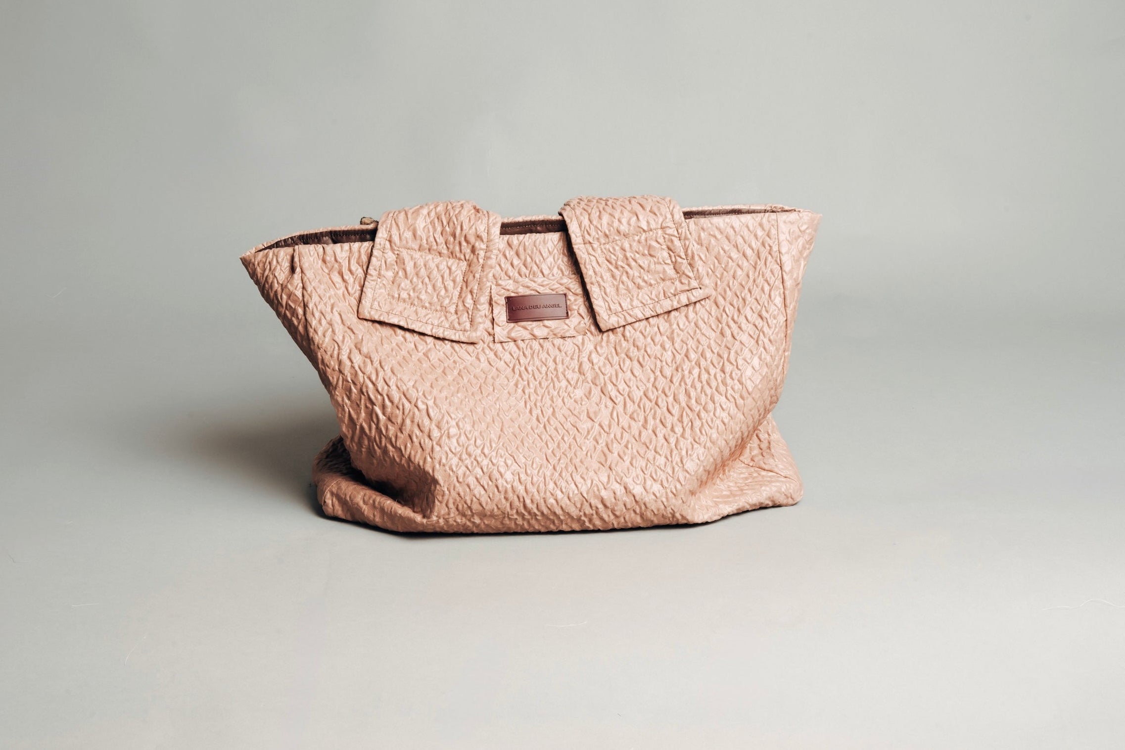 Pink textured handbag on a light gray background